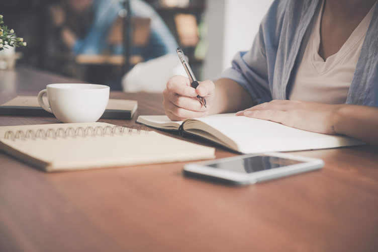 a girl making a list of necessary items for her dorm relocation